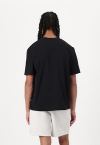 New Balance HOOPS TRADITION GRAPHIC UNISEX - Apdrukāts T-krekls - black
