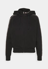 Felpa nera con zip realizzata in tessuto morbido, dotata di cappuccio, cordini e dettagli a strisce sulle spalle con logo.