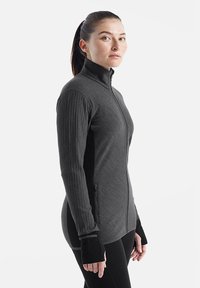 Giacca zip-up grigia con texture a coste sulle maniche e sui lati, caratterizzata da un colletto alto e polsini con foro per il pollice per una maggiore copertura.