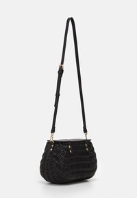Czarna pleciona torebka o zaokrąglonym kształcie, z gładkim wierzchem, regulowanym czarnym paskiem oraz złotymi akcentami na zapięciu i mocowaniach.