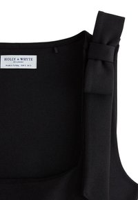 Sort ærmeløs top med en sløjfedetalje på skulderen. Fremstillet af et glat stof, der har en ren halsudskæring og et mærke med størrelse og mærke.