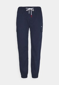 Tmavě modré námořnické kalhoty s elastickým pasem a šňůrkou na zavazování. Mají boční kapsy a zúžené lemy u kotníků. Materiál bavlna.