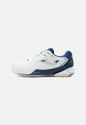 Hvit og marineblå sportsneaker med lisser, teksturert såle og en sølv side-logo på ensfarget hvit bakgrunn.