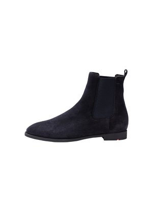 Black suede Chelsea boot with elastic side panel, low heel, and pull tab at the back, shown from the outer side.