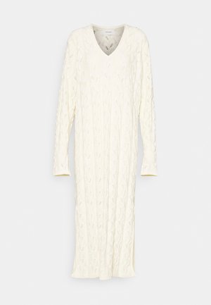 Gestricktes, cremefarbenes Kleid mit V-Ausschnitt und langen Ärmeln. Verfügt über ein strukturiertes, Zopfmuster. Midilänge mit geradem Schnitt.