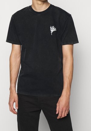 Schwarzes Baumwoll-T-Shirt mit einem kleinen weißen Grafikdesign auf der linken Brust, Rundhalsausschnitt, kurzen Ärmeln und einer lockeren Passform.