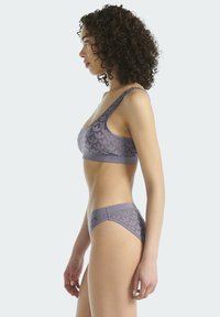 Lilla lingerisæt bestående af en polstret bralette med et botanisk mønster og matchende bikini-trusse, lavet af glat, strækbart stof.