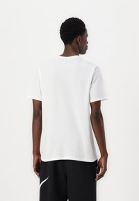 White cotton t-shirt with short sleeves, round neckline, and a relaxed fit. Smooth texture, minimal design, and no visible logos or patterns.