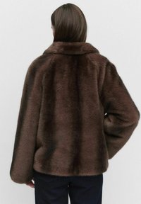 Br�ązowa kurtka z futra syntetycznego z szerokim kołnierzem, w oversize'owym kroju i teksturowanej powierzchni. Tył ma gładkie, puszyste wykończenie oraz długie rękawy.
