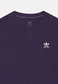 Tmavofialová mikina s krúhovým výstrihom a vyšívaným logom Adidas trefoil na hrudi, s rovnakým logom potlačeným vo vnútri goliera.