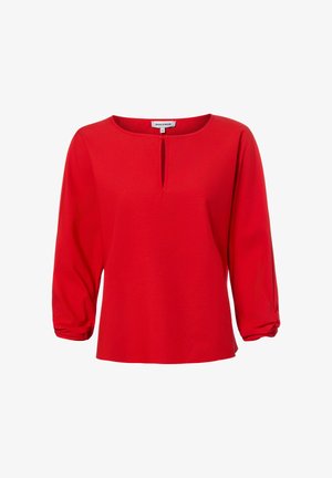 Rode blouse met lange mouwen, een keyhole-halslijn en gerimpelde manchetten, met het label "More & More", getoond op een witte achtergrond.