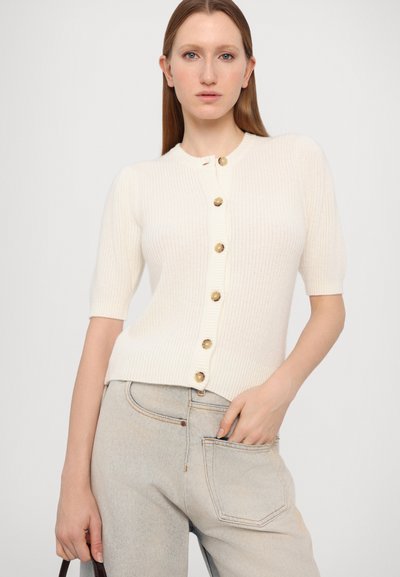 White short-sleeve cardigan made of ribbed knit fabric with a round neckline and seven gold buttons down the front.