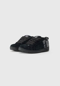 Zwarte suède sneakers met een lage ontwerp, voorzien van platte veters, textuur bovenkant en een logo accent aan de zijkant. Rubberen zool zichtbaar.