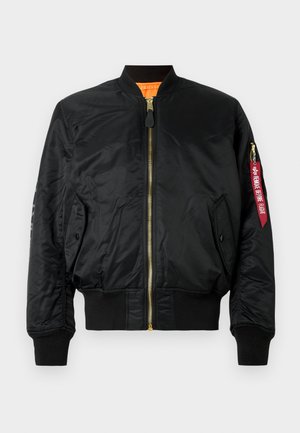 Schwarze Bomberjacke aus glänzendem Material, mit durchgehendem Reißverschluss, gerippten Bündchen und Saum. Auf dem Ärmels befindet sich ein Aufnäher mit roter Schrift.