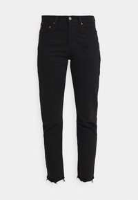 Jeans in denim nero con vestibilità slim, orlo grezzo alle caviglie, bottoni in rame e design classico a cinque tasche.