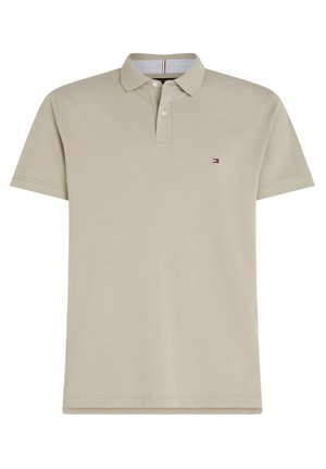 Beiges kurzärmeliges Poloshirt mit Kragen, zwei Knöpfen und einem kleinen roten, weißen und blauen Flaggenlogo auf der linken Brust.