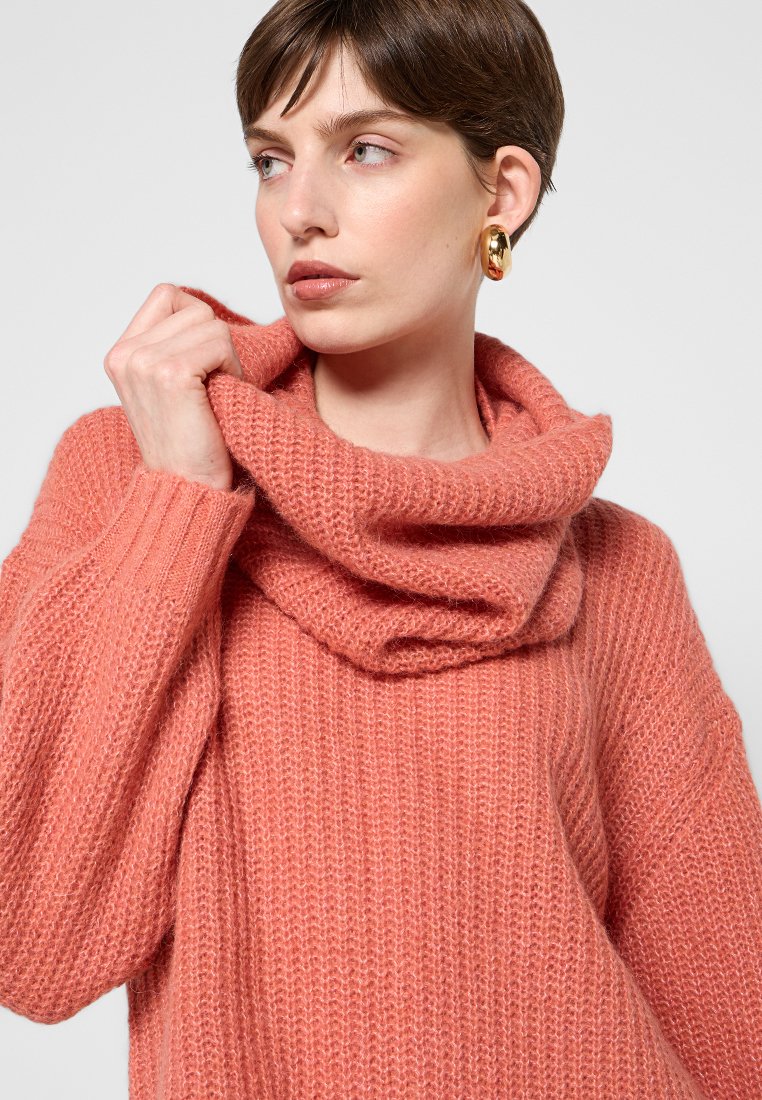 Maglione oversize lavorato a maglia in un morbido corallo, con collo a lupetto e dettagli a coste. Tessuto testurizzato con una vestibilità comoda e ampia.