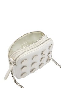 Biała torba na zamek błyskawiczny wykonana z sztucznej skóry, z dziewięcioma metalicznymi okrągłymi ćwiekami na przodzie i srebrnym łańcuszkiem.