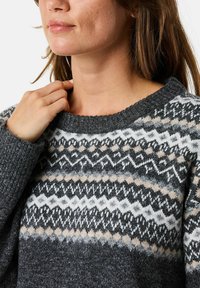 Grijs gemêleerd trui met een geribbelde halslijn en manchetten. Bevat geometrische ontwerpen in zwart, wit en beige. Zachte textuur.