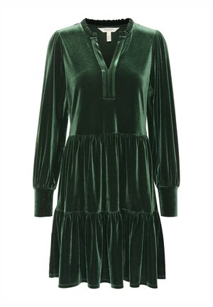 Robe en velours vert avec de longues manches bouffantes, un décolleté en V profond et des niveaux froncés au niveau de la jupe. Texture douce avec une finition brillante.
