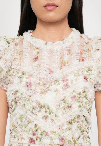 Witte bloemenshirt met gerimpelde textuur, doorschijnende stof en gestreept patroon met roze en groene bloemenaccenten. Puffmouwen, ronde halslijn.