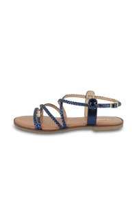 Sandali piatti blu navy con cinturini intrecciati, soletta in pelle liscia e chiusura con fibbia sul cinturino alla caviglia. Design minimalista.