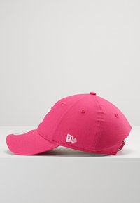 Rosa baseballkeps med en böjd skärm, utrustad med en vit logo på framsidan, sex ventilationshål och en justerbar snapback-stängning.