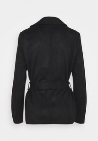 Svart mockakappa med skräddarsydd silhuett, långa ärmar och bälte som knyts i midjan, med en klassisk slagkrage.