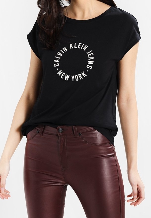 Czarna koszulka z krótkim rękawem i okrągłym dekoltem, ozdobiona białym okrągłym nadrukiem z napisem "Calvin Klein Jeans Nowy Jork". Połączona z bordowymi dopasowanymi spodniami.