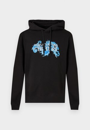 Svart hettegenser med lange ermer og blått dekorativt tekst "Versace Jeans Couture" på brystet, sett forfra mot en lys bakgrunn.