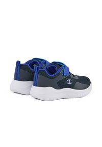 Zapatillas con una parte superior de malla gris oscuro, acentos azules contrastantes, correa de velcro y suela de goma blanca con patrones de agarre.