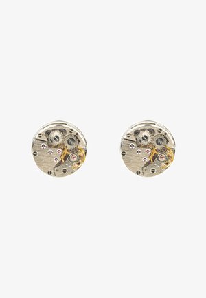 Runde Ohrringe in Silberoptik mit sichtbarem Uhrwerk, Zahnrädern und lila Akzenten, kombiniert mit einer gebürsteten Metalloberfläche und detaillierten Verzierungen.