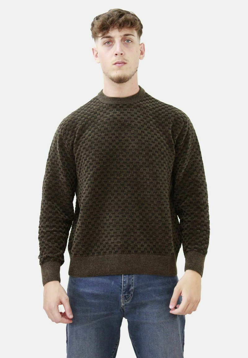 Maglione a maglia verde scuro con un motivo testurizzato, scollo a girocollo e polsini e orlo a coste, abbinato a jeans blu.