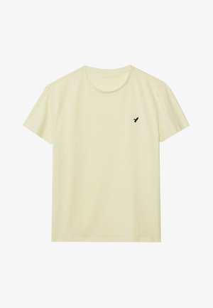 T-shirt en coton jaune clair avec un col rond, des manches courtes et un petit logo d'oiseau noir sur la poitrine gauche. Texture douce.
