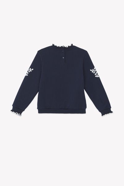Felpa blu navy con colletto testurizzato, chiusura a tre bottoni e ricamo floreale sulle maniche. Tessuto morbido e dettagli a costine sui polsini.