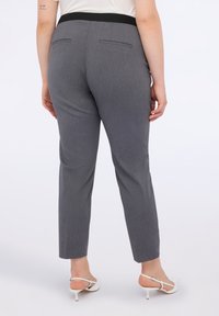 Šedé kalhoty na míru se slim fit střihem, s černým pasem, dvěma zadními kapsami a hladkým povrchem.