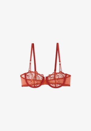 Soutien-gorge en dentelle rouge transparente avec armatures, bords festonnés et bretelles décoratives. Comprend un dos en mesh et un motif floral détaillé sur l'ensemble.