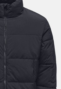 Puffer jacket in dark navy fabric with horizontal stitching, high collar, full zip closure, and front pocket detailing.