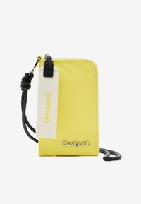 Geel pouch met een gladde textuur, zwarte rits en geweven hengsel. Voorzien van een geprinte label en een reliëflogo aan de voorkant.