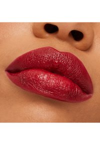 Deep red lips with a glossy finish, featuring subtle texture and defined shape, set against smooth, light skin.