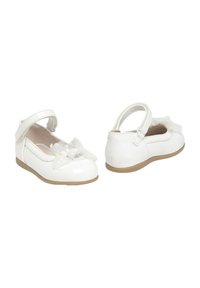 Zapatos de charol blancos con un lazo de tela transparente, parte trasera cerrada, correa ajustable y suela de goma marrón claro.