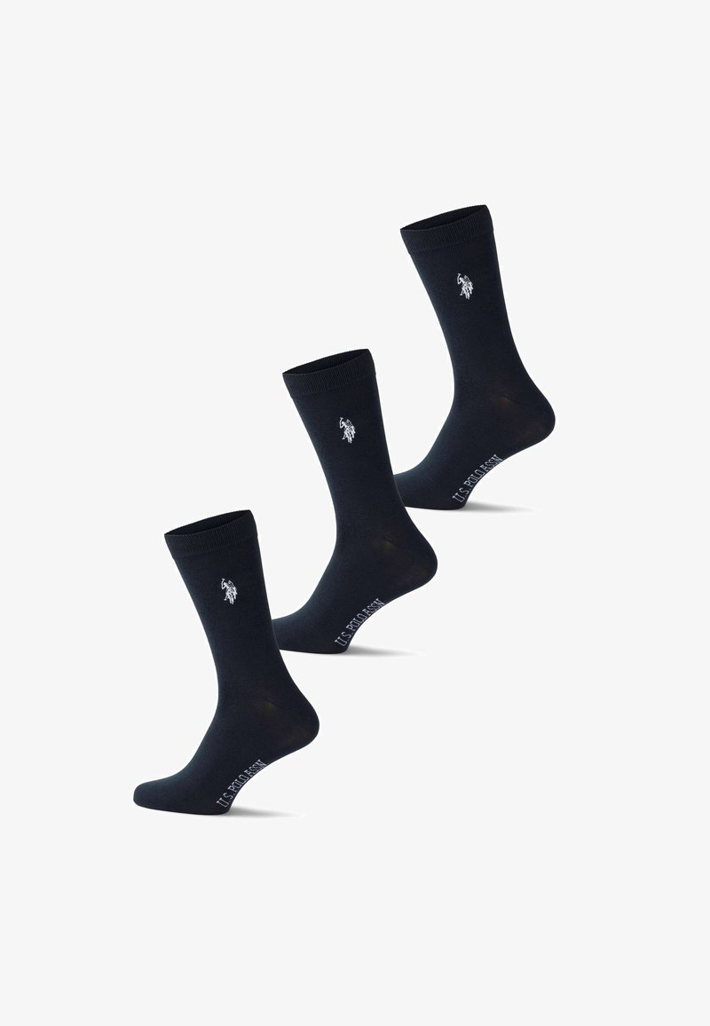 Trois chaussettes noires montantes avec le logo blanc U.S. Polo Assn. près du haut et le nom de la marque sur la voûte plantaire.
