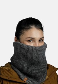 Knit gray neck warmer with a ribbed texture, featuring a folded design and a small leather accent. Worn over an olive-brown jacket.