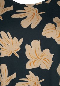 Tessuto a maglia con grandi motivi floreali bianco sporco e accenti arancioni su uno sfondo blu scuro. Texture morbida, scollatura rotonda.