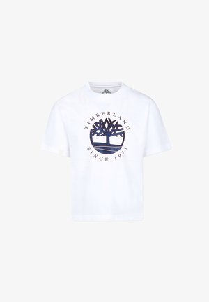 T-shirt en coton blanc avec un col rond, des manches courtes et un logo graphique central représentant un arbre accompagné du texte "TIMBERLAND SINCE 1973" en bleu marine.