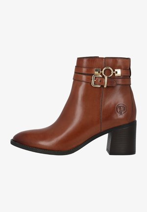 Braune Leder-Ankle-Boots mit einer abgerundeten Zehenpartie, zwei dekorativen Riemen, goldfarbenen Hardware-Details und einem strukturierten Blockabsatz. Logo auf der Seite eingraviert.