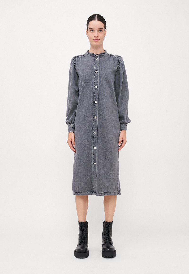 Harmaa farkkukleid, jossa on pitkät puffihihat, nappi etuosa ja midi pituus. Sisältää kerättyä kaula-aukkoa ja kontrastiväriset hopean väriset napit.