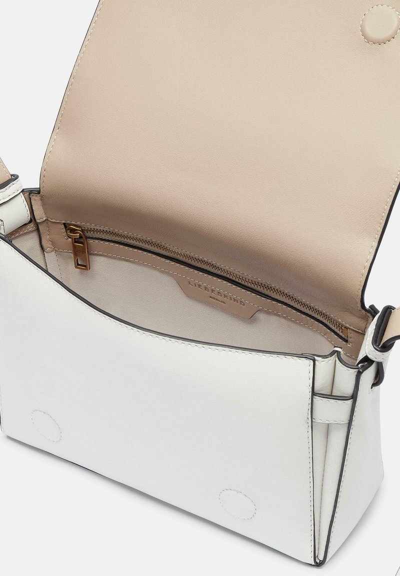 Weiße Lederhandtasche mit beigem Innenraum, ausgestattet mit einer Reißverschlussinnentasche und einem Klappenverschluss. Beinhaltet einen verstellbaren Tragegurt und minimalistische Nähte.