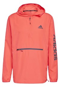 Kirkas korallinvärinen vedenpitävä takki, jossa on puoli-vetoketju edessä, säädettävä huppu, joustavat hihansuut ja vetoketjullinen tasku edessä. Musta logo.