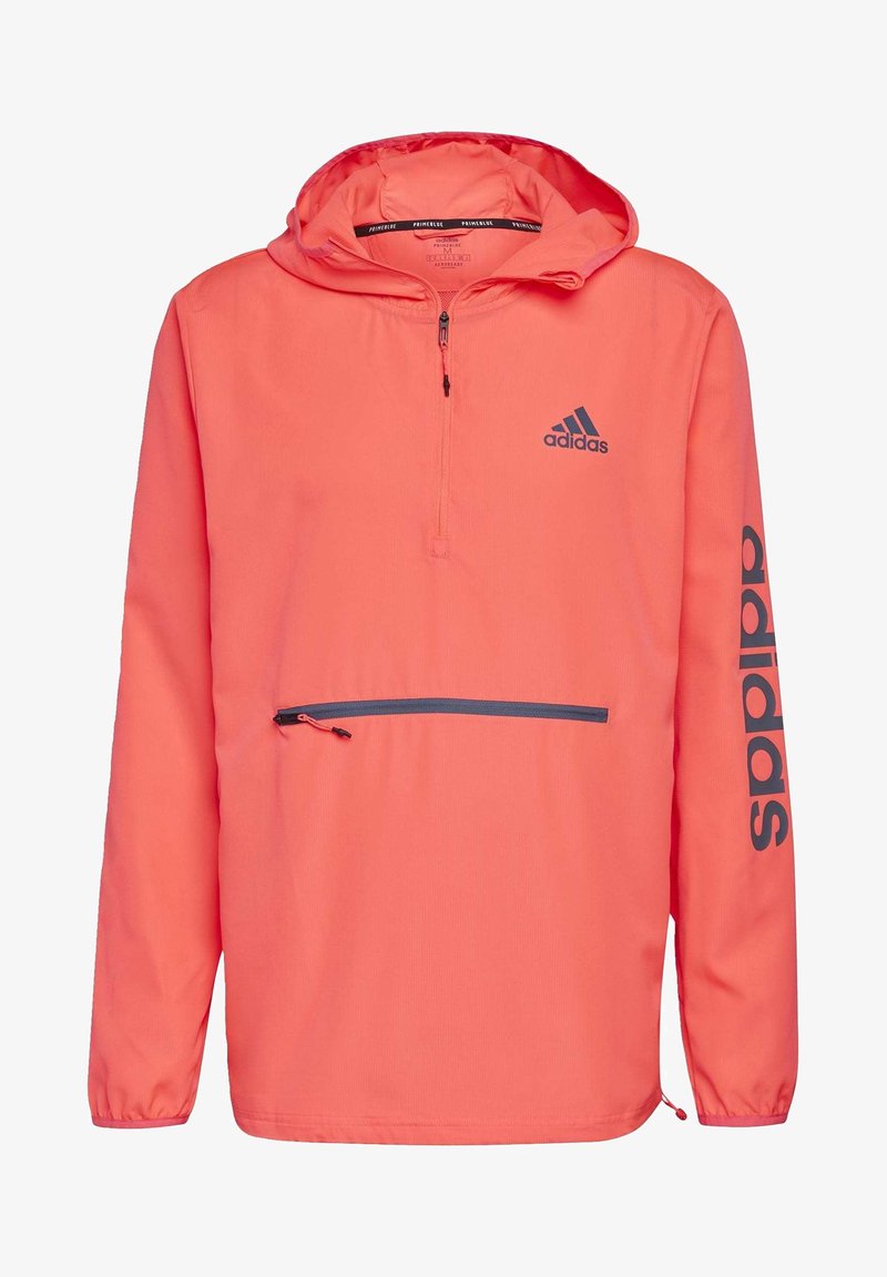 Kirkas korallinvärinen vedenpitävä takki, jossa on puoli-vetoketju edessä, säädettävä huppu, joustavat hihansuut ja vetoketjullinen tasku edessä. Musta logo.